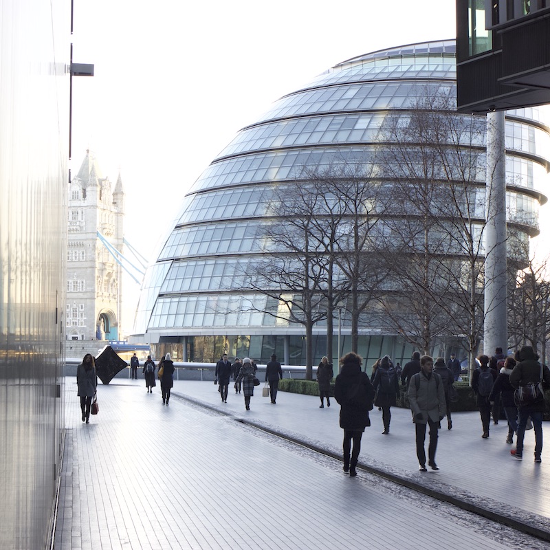 People walking in More place, with London City Hall in the background.